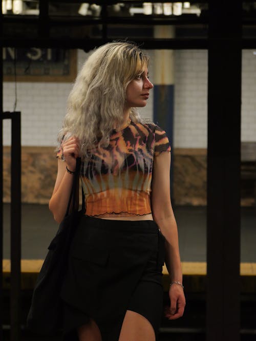 A woman in a skirt and top standing in a subway station