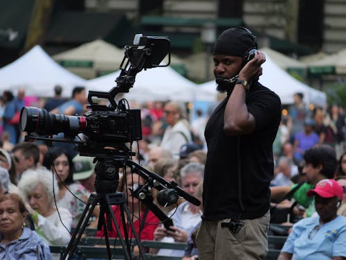 A man with a camera is recording a crowd