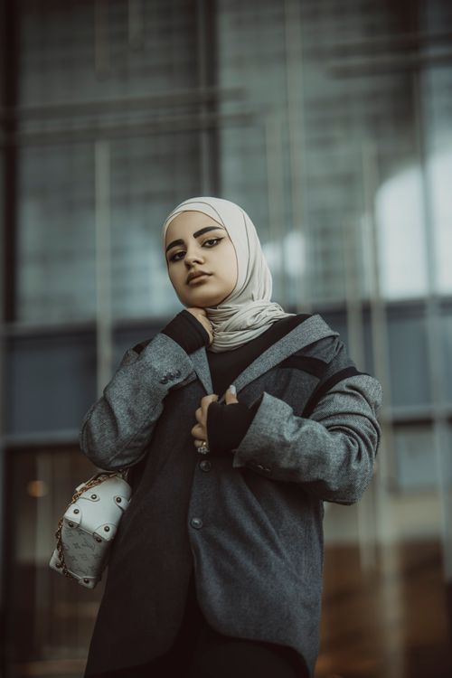 Free Young woman in hijab, stylish outfit, urban background, embracing modern fashion. Stock Photo