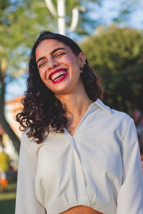 Young Brunette with Red Lips Standing Outside and Smiling 