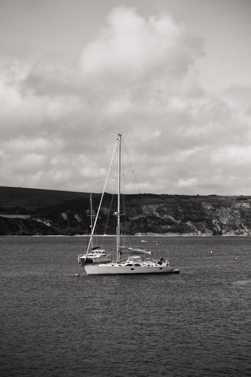 Free Elegant sailboats in a serene black and white scene on a calm sea. Stock Photo