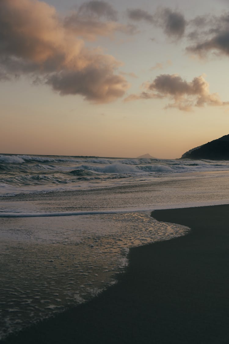 Waves Breaking On Beach At Dusk