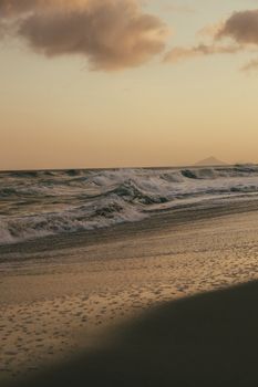 Captivating sunset view over a serene beach with gentle waves and golden skies.