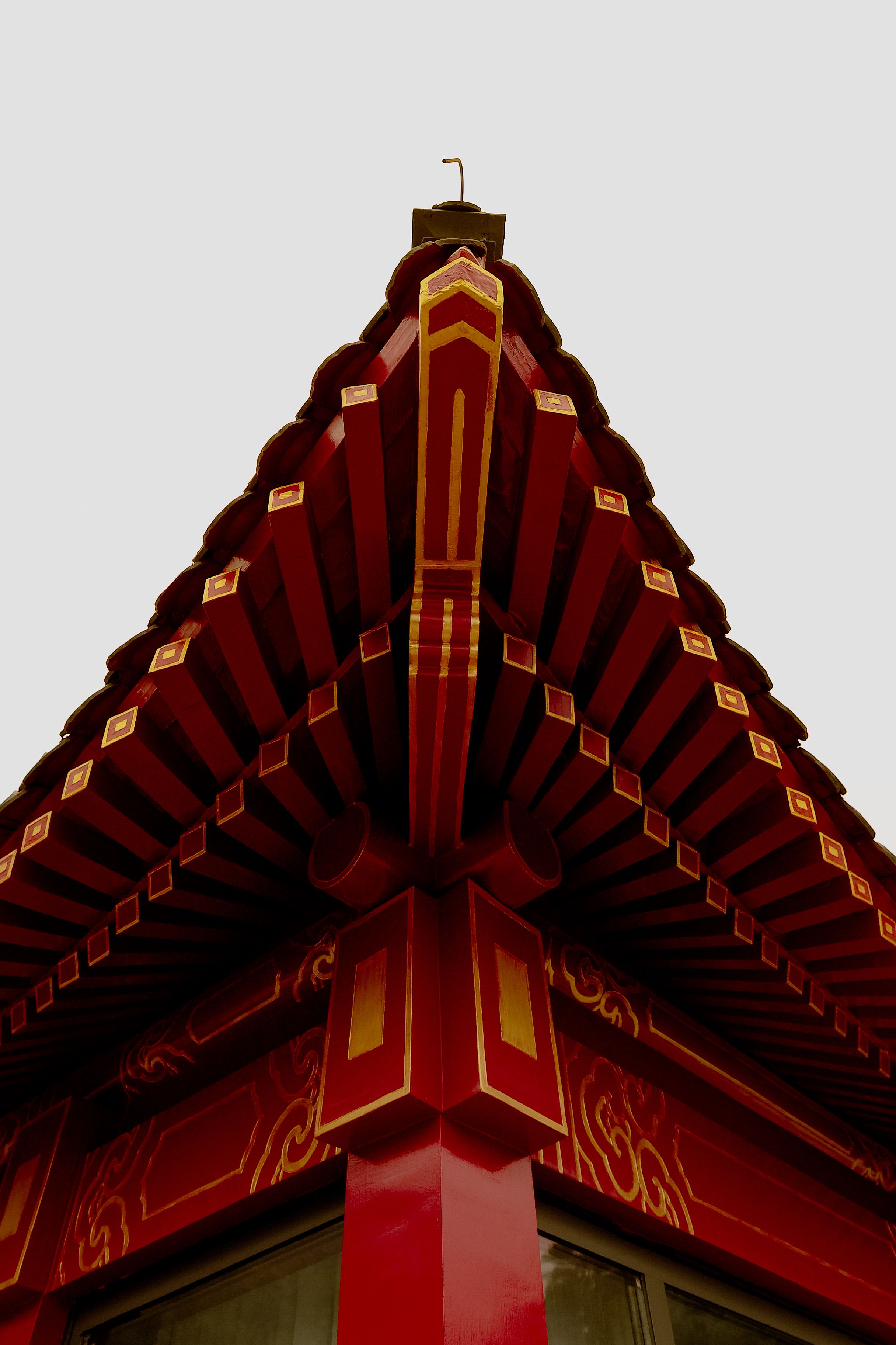 Close-up shot of a traditional Chinese roof with intricate designs and vibrant red colors.
