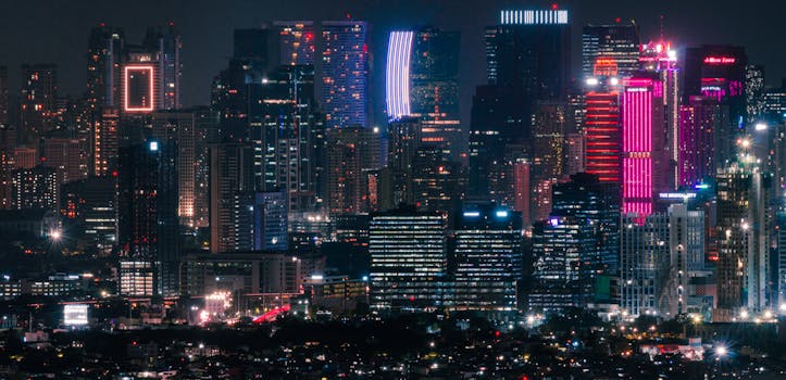 Dynamic cityscape showcasing a modern skyline with colorful neon lights illuminating the night.