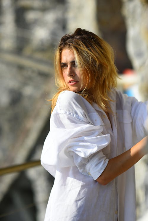 Young Woman in a White Shirt Standing Outside in Sunlight 