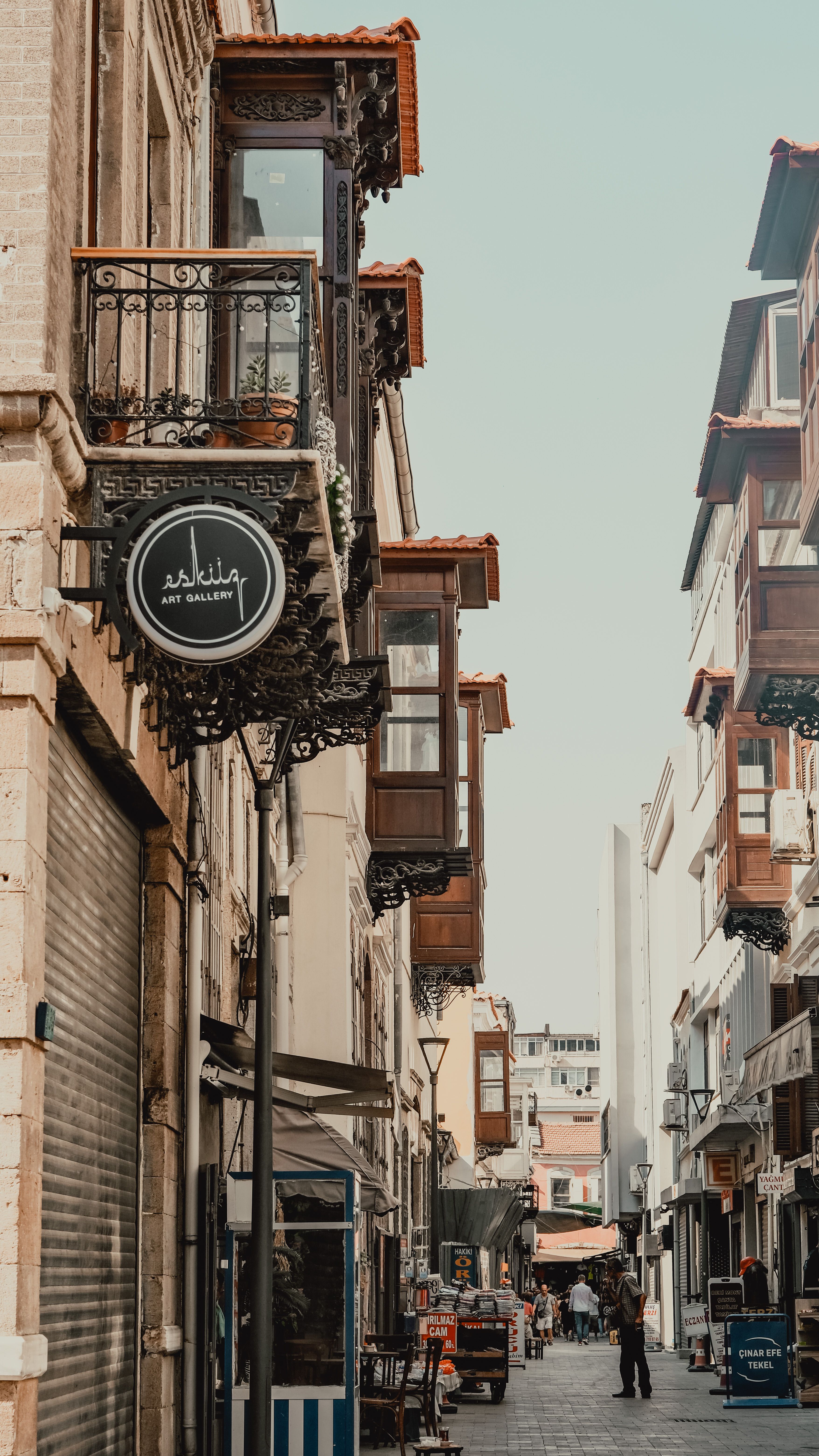Discover the historic charm of İzmir with narrow alleyways and ornate balconies in this urban landscape.