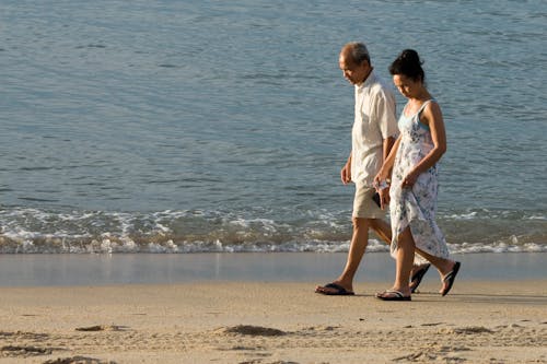 Free Holding Hands Couple Walking on Beach Stock Photo
