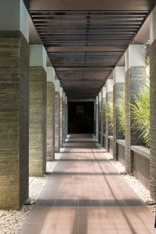 Free Empty colonnade with stone columns and plants, perfect for architectural themes. Stock Photo