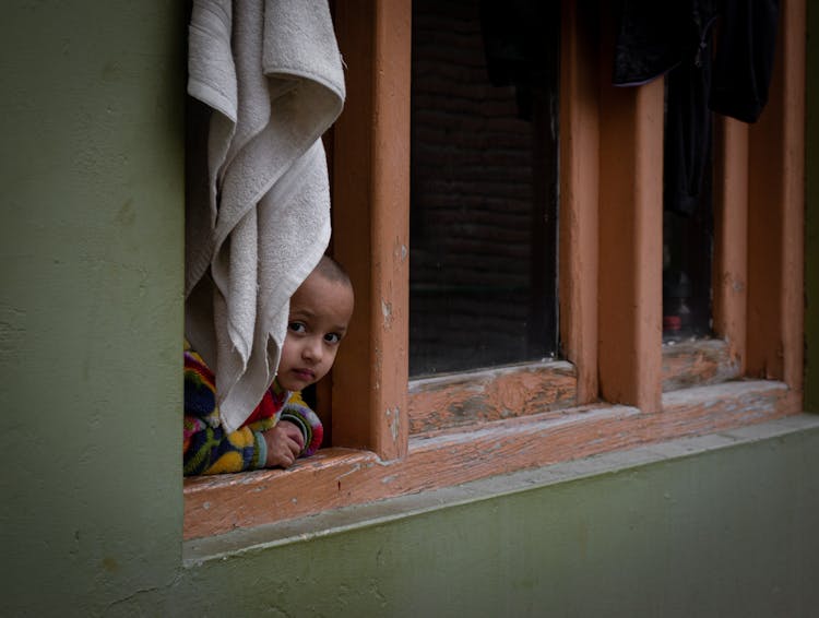 Child Looking Out Through Window