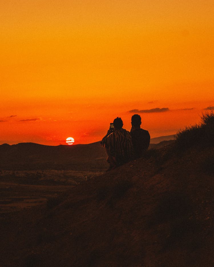 Silhouette Of A Couple Looking At Sunset