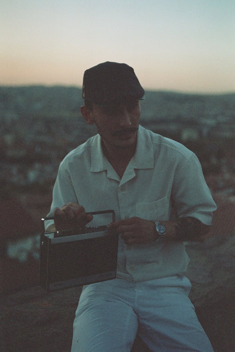 Man Holding A Radio In A Mountain Valley