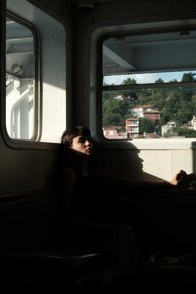 Woman Sitting In Darkness In Corner On Ferry