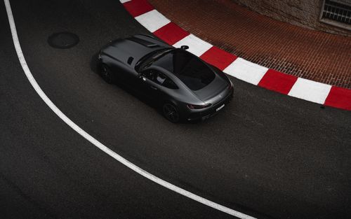 Free Top view of a sleek luxury car navigating a sharp race track curve. Stock Photo
