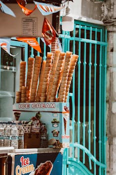 A vibrant street stall showcasing tall stacks of waffle cones for ice cream in an urban setting.