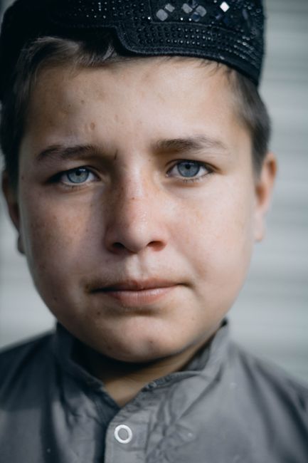 Close-up portrait of a young boy wearing a traditional cap, showcasing innocence and expression.