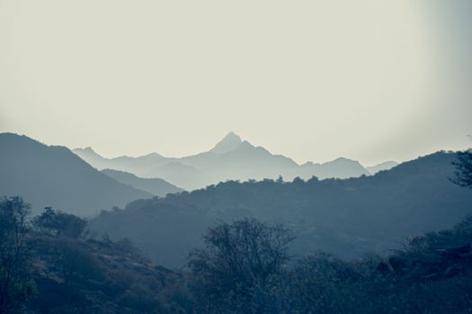 Calm mountain landscape with misty hills in the early morning light, perfect for nature lovers.