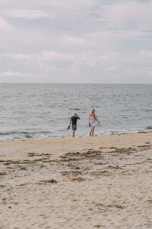 Free Couple Walking on the Beach on a Windy Day Stock Photo