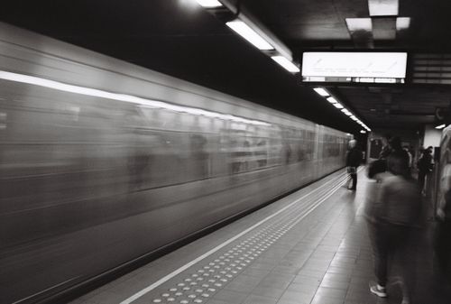 Free Dynamic black and white metro station scene in Brussels with commuters waiting. Stock Photo