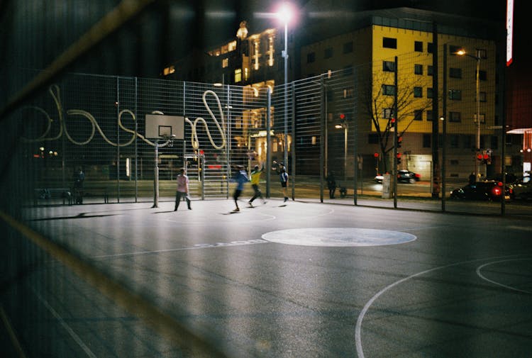 Men Playing Basketball At Night