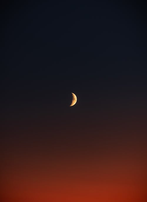 The moon is seen in the sky at sunset