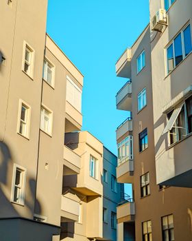 Low angle view of modern residential buildings against a clear blue sky.