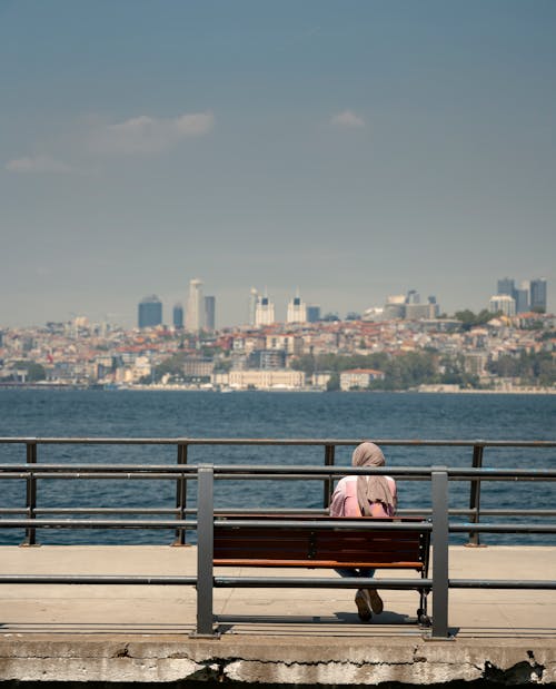 Woman in Hijab Sitting on Bench on Pier