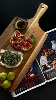 Appetizing fig and avocado toast on rustic cutting board, perfect for health-conscious foodies.