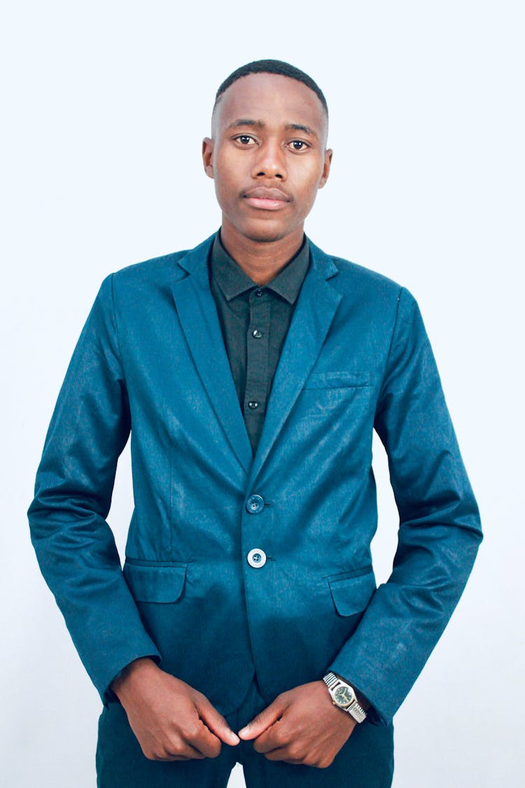 Portrait Of Black Man In Suit Posing On White Studio Background