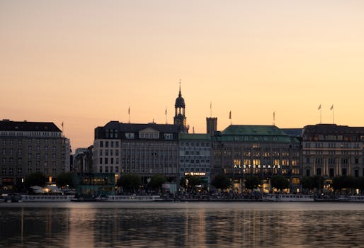 Scenic view of Hamburg skyline with Alster Lake at sunset, highlighting the city's architecture.
