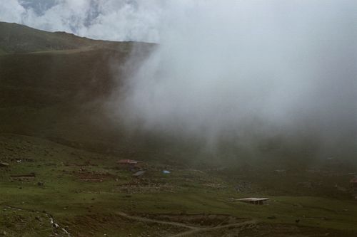 Free Serene landscape with misty hills and grassland under a foggy sky. Stock Photo