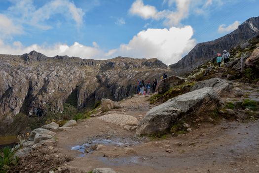 Explore the rugged beauty of Mérida's mountain range with hikers on a scenic trail.