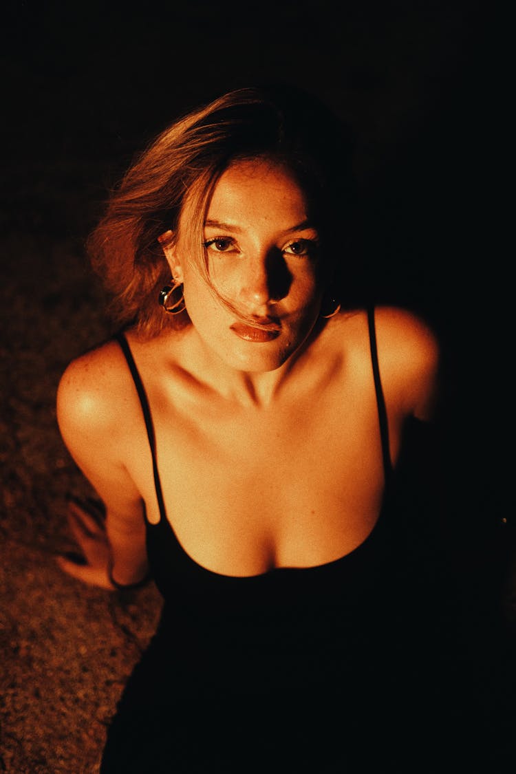 Brunette Woman In Black Strap Dress Sitting On The Ground