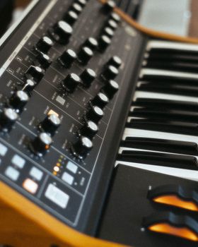 An artistic close-up of a synth keyboard with focus on controls, ideal for music and technology themes.