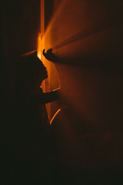 Silhouette of an individual illuminated by warm glow, creating dramatic shadows and ambiance in Baku.