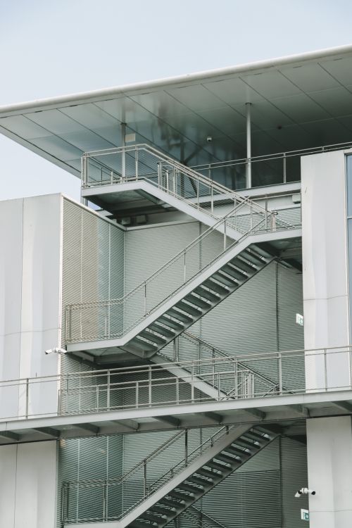 Free Sleek urban building featuring contemporary external staircases in a modern design. Stock Photo