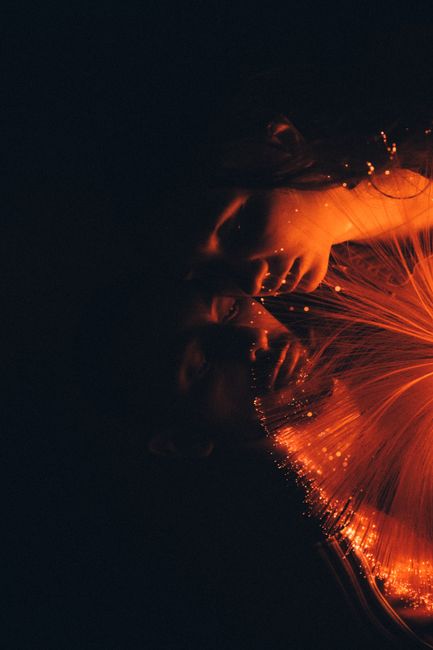 A tender moment between a couple illuminated by vibrant fiber optic light.