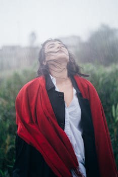 Portrait of a woman with closed eyes and long hair enjoying the rain outdoors in Baku, Azerbaijan.