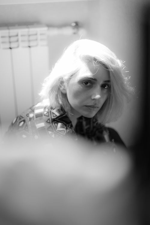 Free Artistic black and white portrait of a blonde woman with dyed hair sitting indoors. Stock Photo