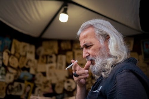 Long-Haired Senior Smoking a Cigarette