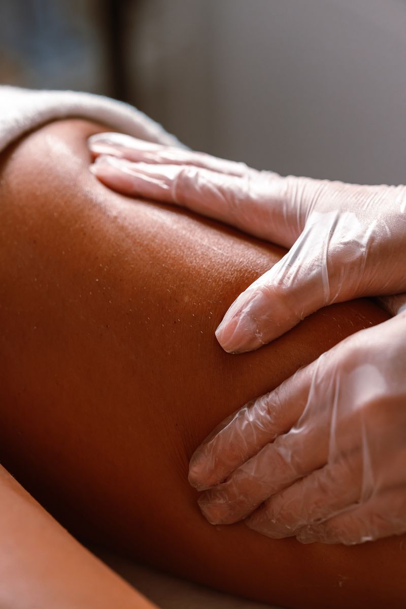 Esthetician in gloves preparing skin before waxing