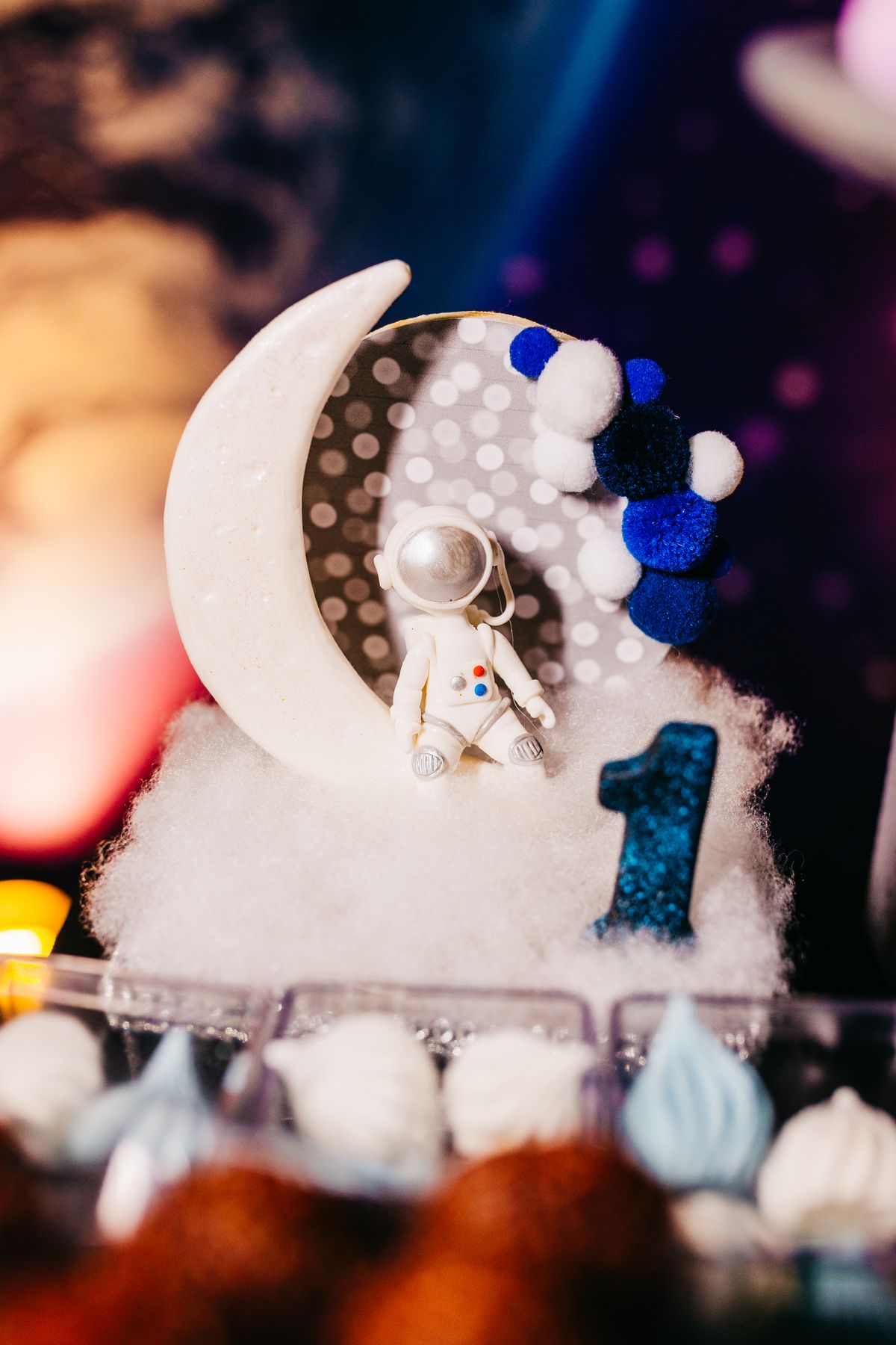 Space-themed cake decoration with an astronaut figurine and moon, perfect for celebrations. Stock Photo.