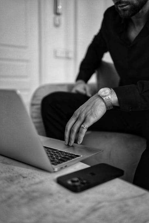 Black and White Photo of a Man Using Laptop 