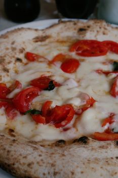 Close-up of a freshly baked Margherita pizza with melted cheese and tomatoes.