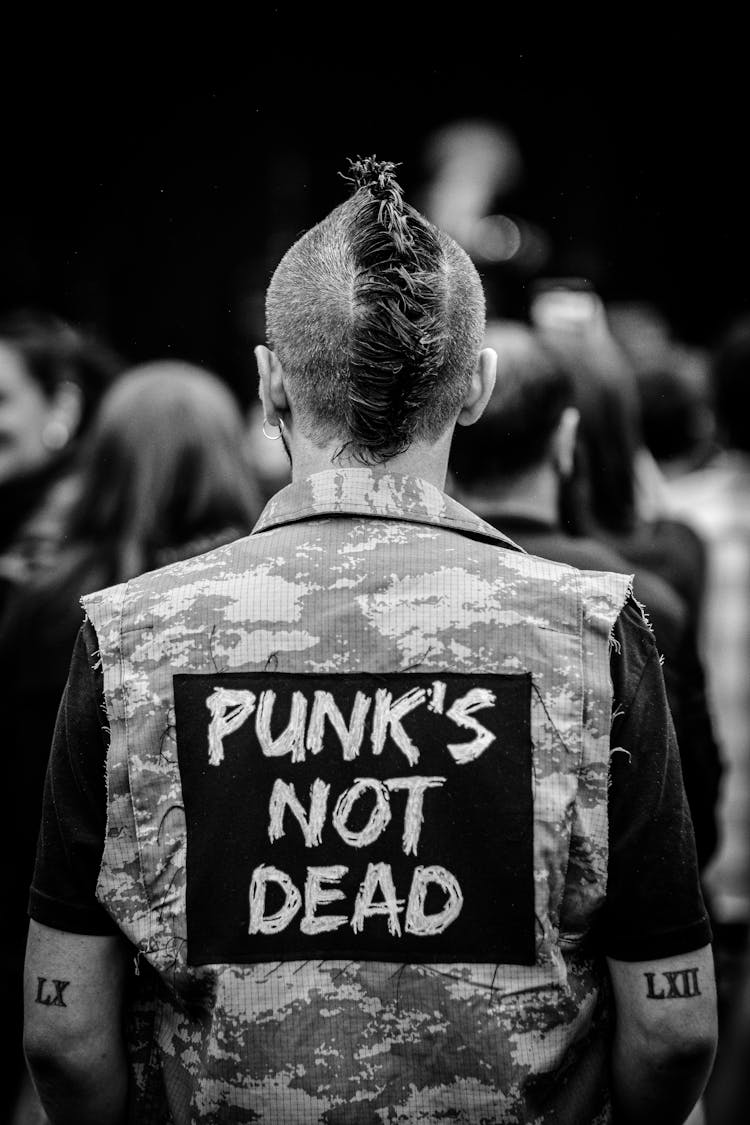 Back View Of A Man In A Military Jacket Standing In The Crowd In Black And White