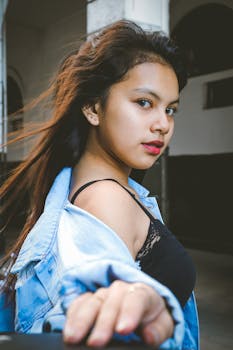 一位时尚年轻女子，穿着牛仔夹克，头发飘逸的肖像