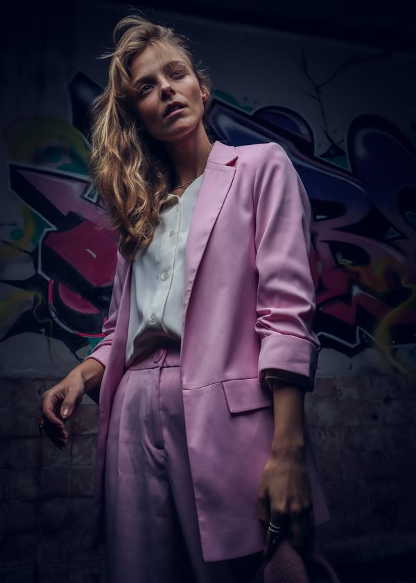 Woman wearing a pastel pink linen suit in spring