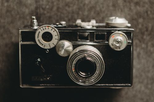 Free Close-up photo of a vintage camera with a textured gray background. Stock Photo