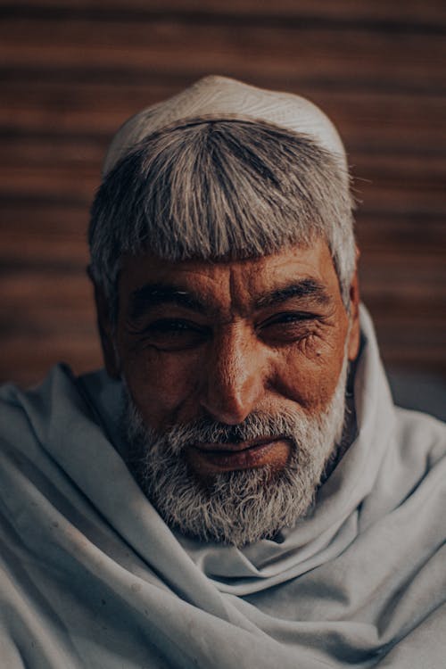 Portrait of a Bearded Senior Man in Grey Shawl and Cap