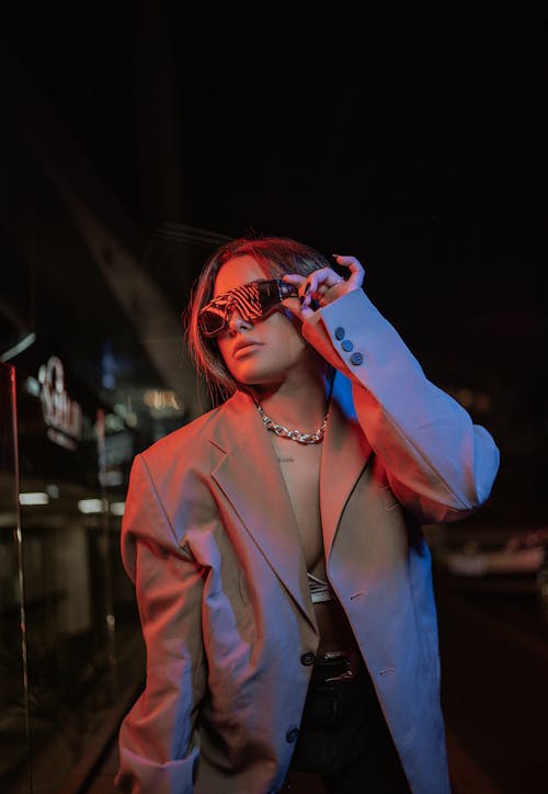 Young Fashionable Woman in Sunglasses Posing in City at Night 